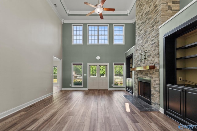 123 Coyote Creek Rd, Meridianville, AL 35759 - unfurnished living room with a stone fireplace, a ceiling fan, crown molding, wood finished floors, and a raised ceiling