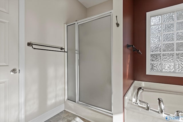 123 Coyote Creek Rd, Meridianville, AL 35759 - bathroom featuring a bathtub, a shower with shower door, baseboards, and plenty of natural light