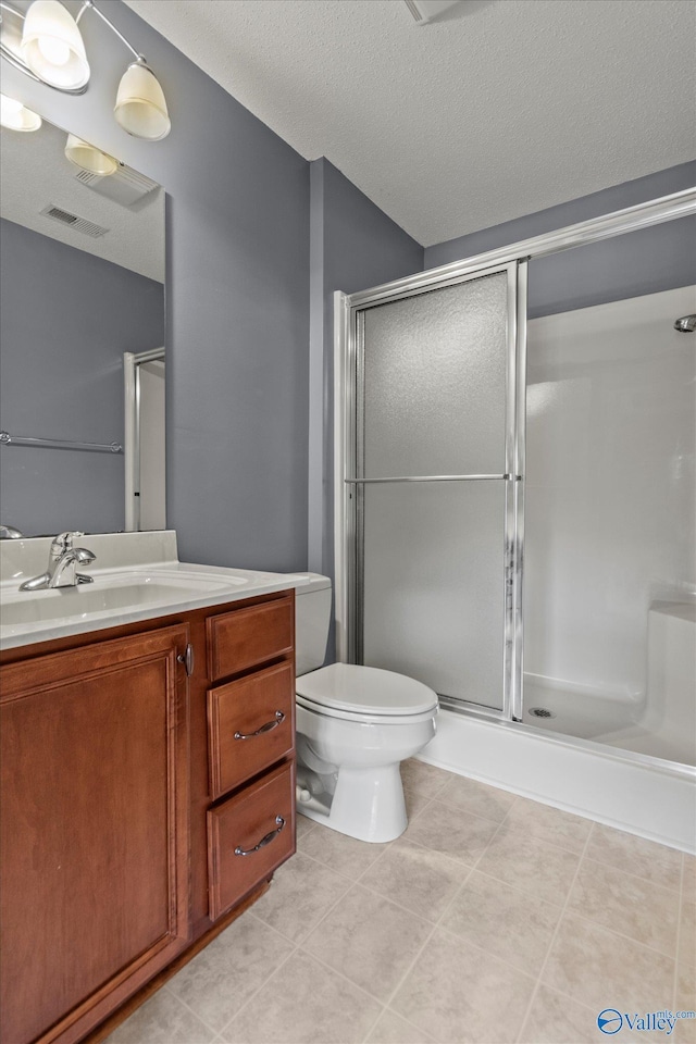 123 Coyote Creek Rd, Meridianville, AL 35759 - full bathroom with a stall shower, vanity, toilet, tile patterned flooring, and a textured ceiling