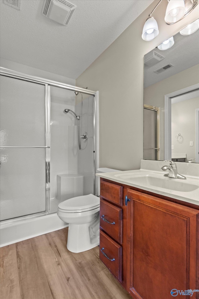 123 Coyote Creek Rd, Meridianville, AL 35759 - full bath featuring wood finished floors, a stall shower, toilet, vanity, and a textured ceiling