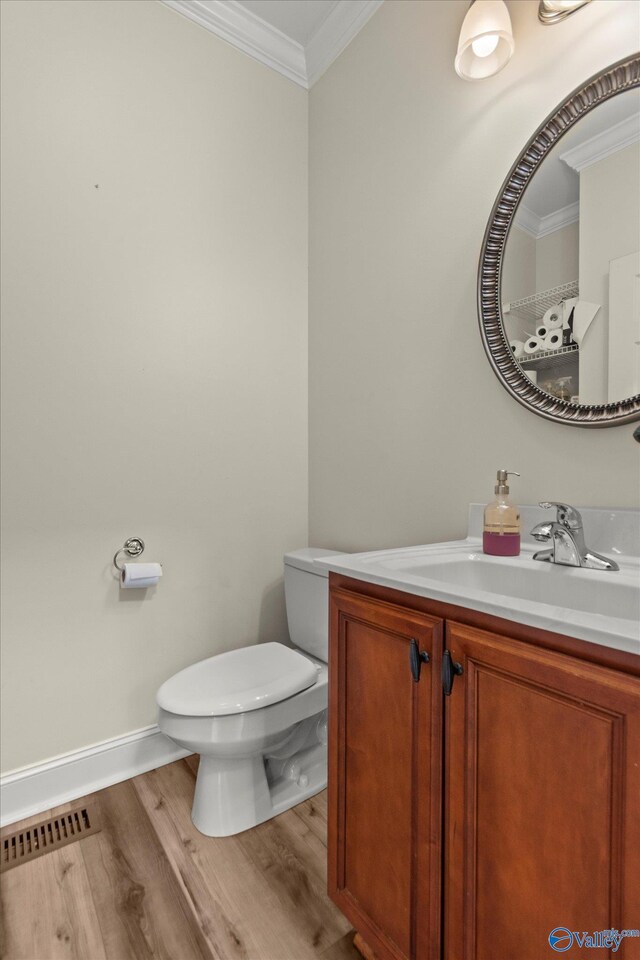 123 Coyote Creek Rd, Meridianville, AL 35759 - bathroom with crown molding, wood finished floors, toilet, vanity, and baseboards