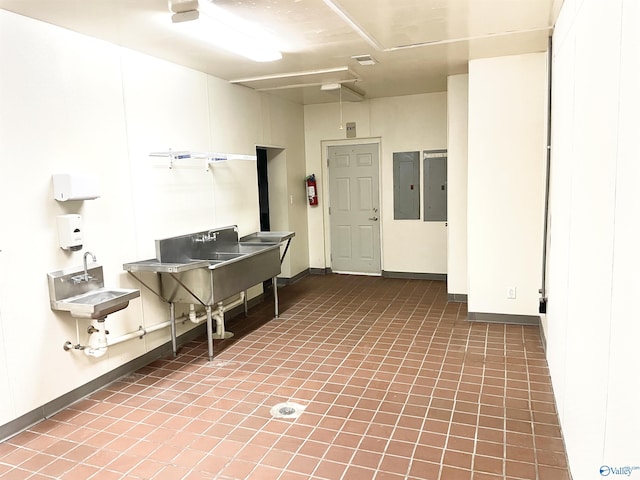 interior space featuring a sink, baseboards, and electric panel