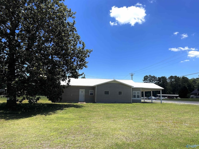 view of front facade featuring a front lawn, driveway, and metal roof