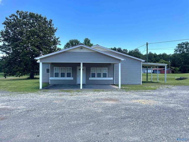 exterior space with a porch, a carport, and a front yard