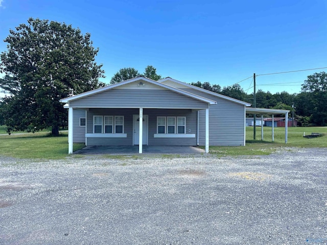 view of front of property featuring driveway, a front yard, and covered porch