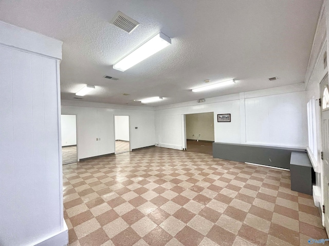 basement featuring light tile patterned floors and a textured ceiling