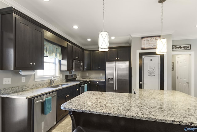 kitchen with stainless steel appliances, decorative light fixtures, sink, and ornamental molding