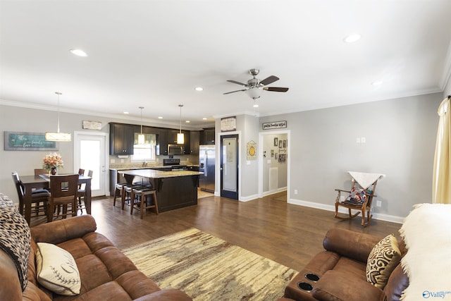 living room featuring dark wood-type flooring, ceiling fan, and ornamental molding