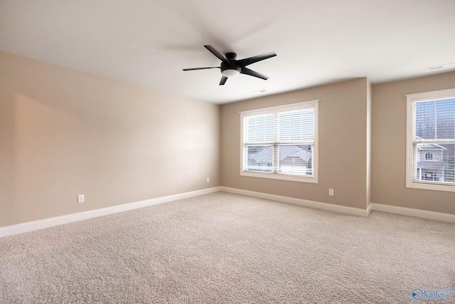 carpeted empty room featuring a wealth of natural light and ceiling fan