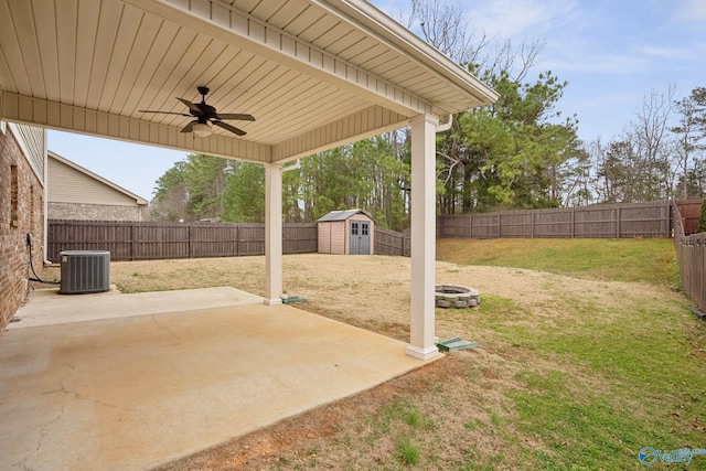 view of yard with a storage shed, a patio area, an outdoor fire pit, cooling unit, and ceiling fan