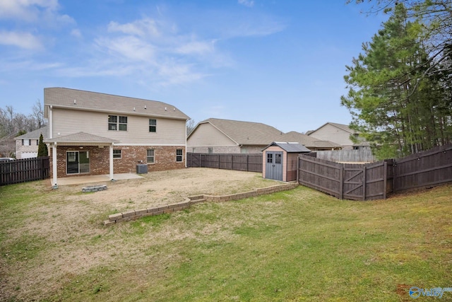 back of property with a patio, a lawn, and a storage shed