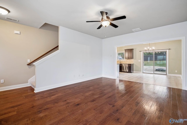 unfurnished living room featuring hardwood / wood-style flooring and ceiling fan with notable chandelier