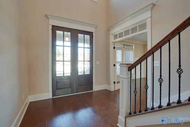 foyer entrance with crown molding, french doors, and dark wood-type flooring