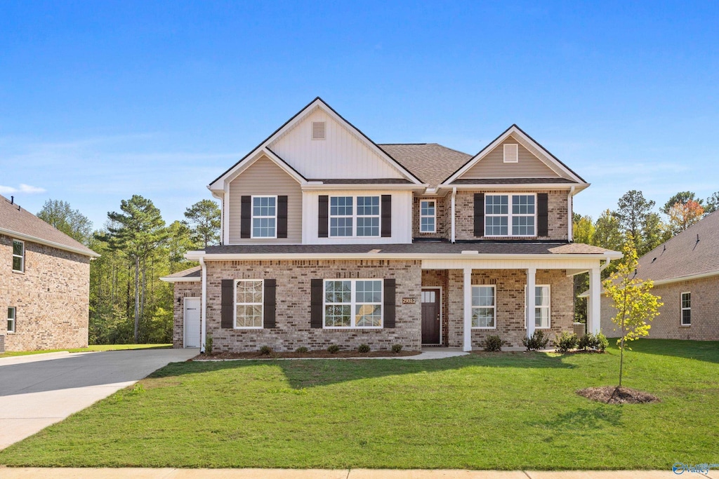 craftsman inspired home featuring a front yard and covered porch