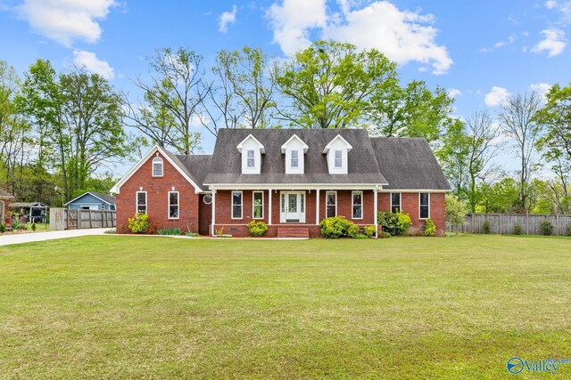 cape cod home featuring fence, a porch, a front lawn, and brick siding