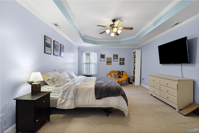 bedroom featuring a tray ceiling, visible vents, ornamental molding, and light carpet