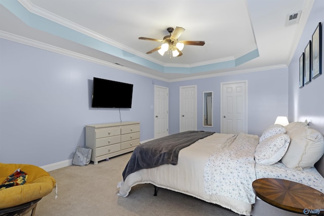 carpeted bedroom featuring ceiling fan, visible vents, crown molding, a raised ceiling, and baseboards