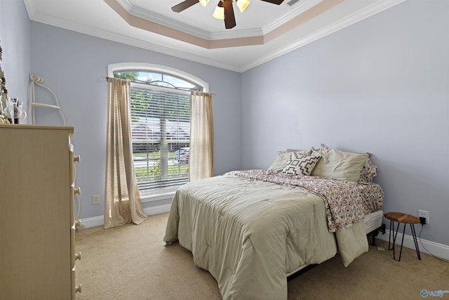 bedroom featuring crown molding, a tray ceiling, multiple windows, and light carpet