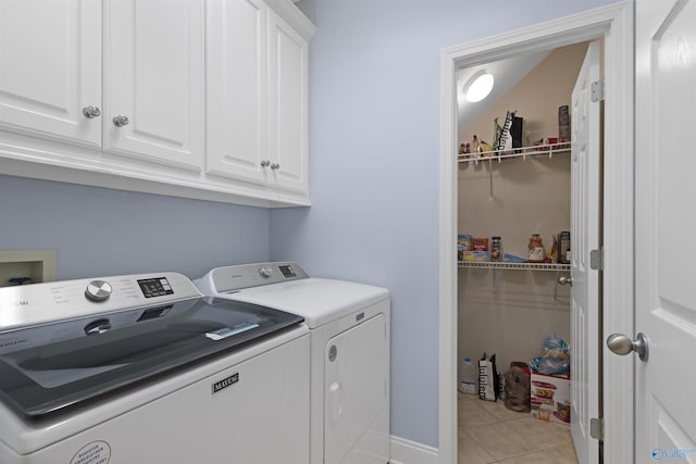 laundry area featuring cabinet space, light tile patterned flooring, and washing machine and clothes dryer