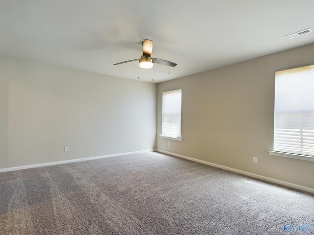 carpeted empty room featuring a wealth of natural light and ceiling fan