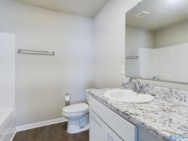 bathroom with toilet, vanity, and hardwood / wood-style floors