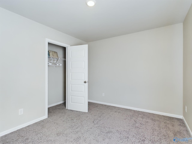 unfurnished bedroom featuring light carpet and a closet