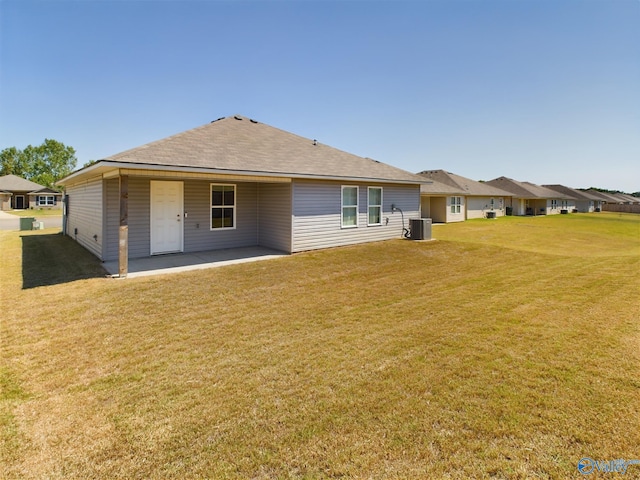 back of house featuring central AC unit, a lawn, and a patio area