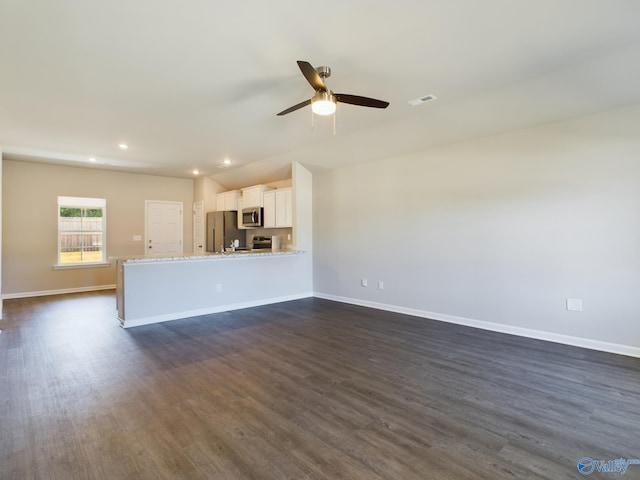 unfurnished living room with dark hardwood / wood-style flooring and ceiling fan