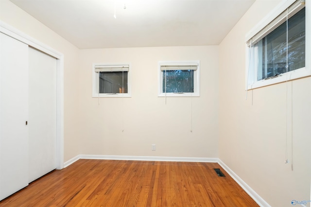 unfurnished bedroom with a closet and hardwood / wood-style floors