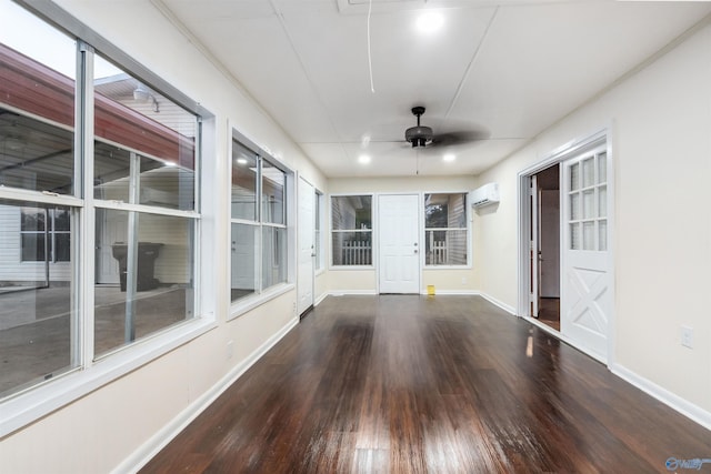 unfurnished sunroom with ceiling fan and a wall mounted air conditioner