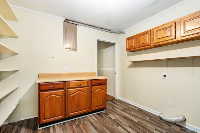 kitchen with ornamental molding, wood walls, and dark wood-type flooring