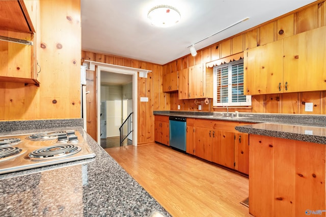 kitchen with sink, white gas stovetop, light hardwood / wood-style flooring, wooden walls, and stainless steel dishwasher