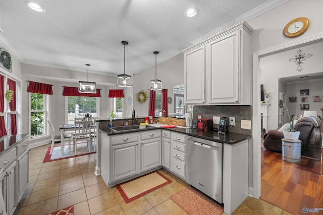 kitchen with white cabinets, sink, kitchen peninsula, stainless steel dishwasher, and backsplash