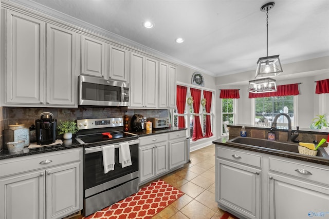 kitchen with ornamental molding, appliances with stainless steel finishes, tasteful backsplash, and sink