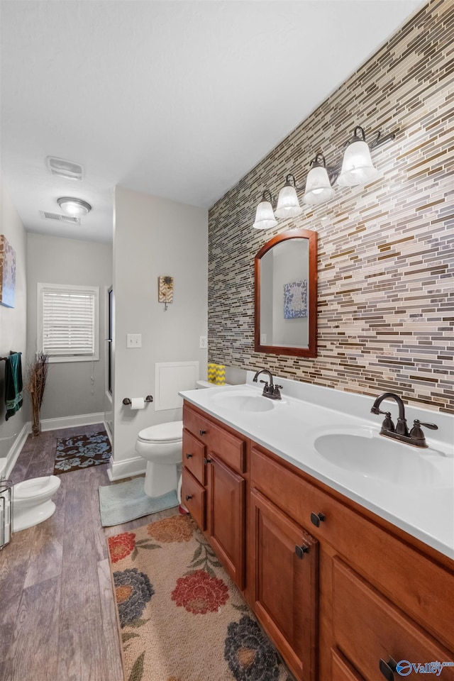 bathroom featuring wood-type flooring, vanity, and toilet