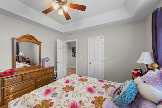 bedroom with a tray ceiling and ceiling fan