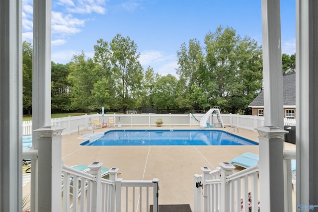 view of swimming pool featuring a patio and a water slide