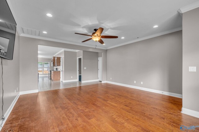 unfurnished living room featuring ceiling fan, ornamental molding, and light hardwood / wood-style floors