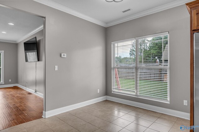 spare room with light wood-type flooring and crown molding