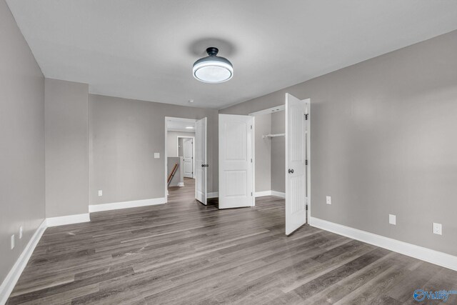 unfurnished bedroom featuring a closet and dark hardwood / wood-style floors