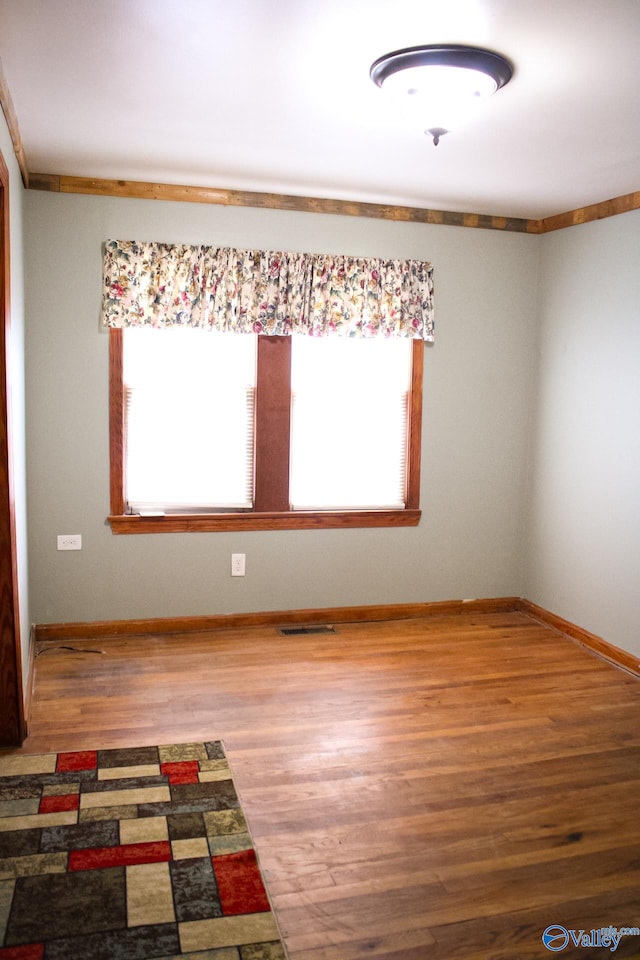 spare room with wood-type flooring and a wealth of natural light