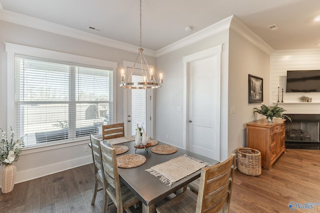 dining space featuring dark wood-style flooring, visible vents, and crown molding