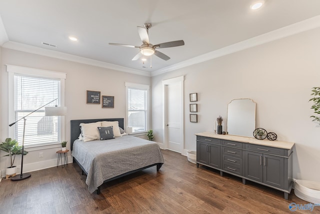 bedroom with dark wood-style floors, visible vents, baseboards, and crown molding