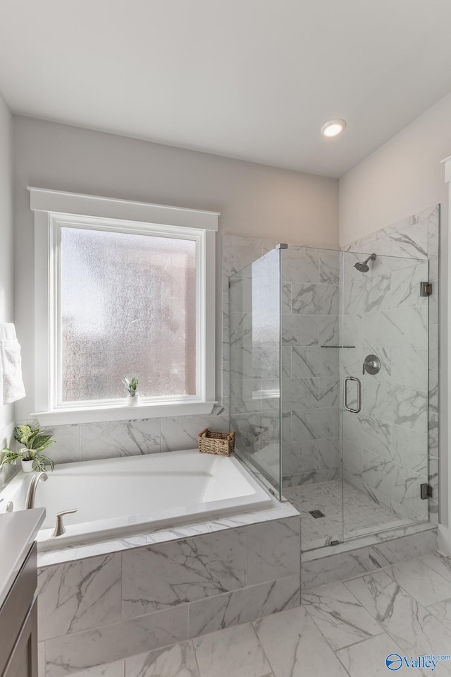 full bath featuring a wealth of natural light, a garden tub, vanity, and a marble finish shower