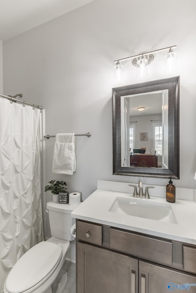 full bath featuring toilet, a shower with curtain, vanity, and ensuite bathroom