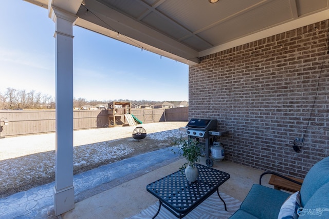 view of patio / terrace with area for grilling, a playground, and a fenced backyard