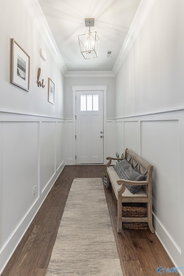 interior space with an inviting chandelier, visible vents, dark wood finished floors, and crown molding