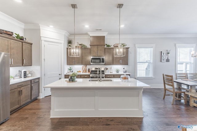 kitchen with a kitchen island with sink, appliances with stainless steel finishes, and pendant lighting