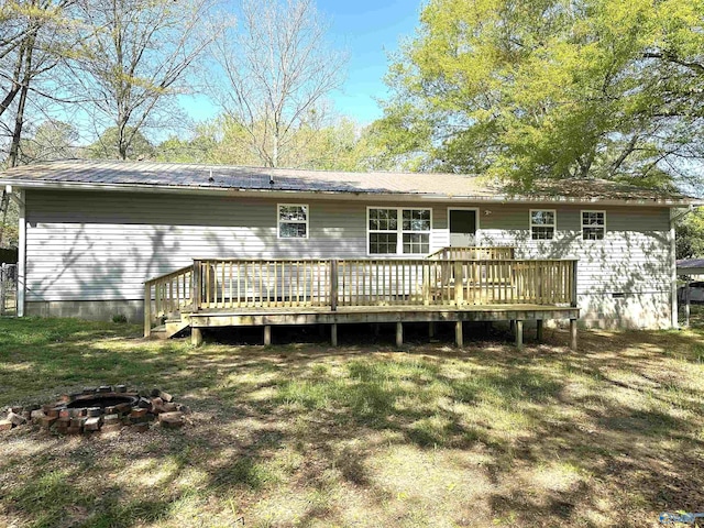 rear view of house featuring a deck, crawl space, and an outdoor fire pit