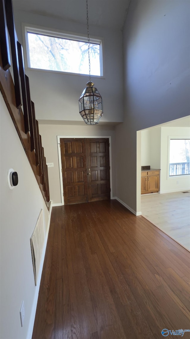 foyer with dark wood-type flooring and a high ceiling